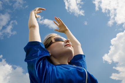 The girl in sunglasses reaches for the sky