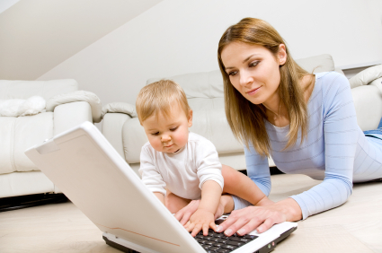 Mother and baby with laptop in living room