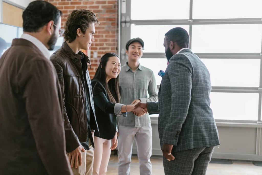 angel investor shaking hands with young entrepreneurs