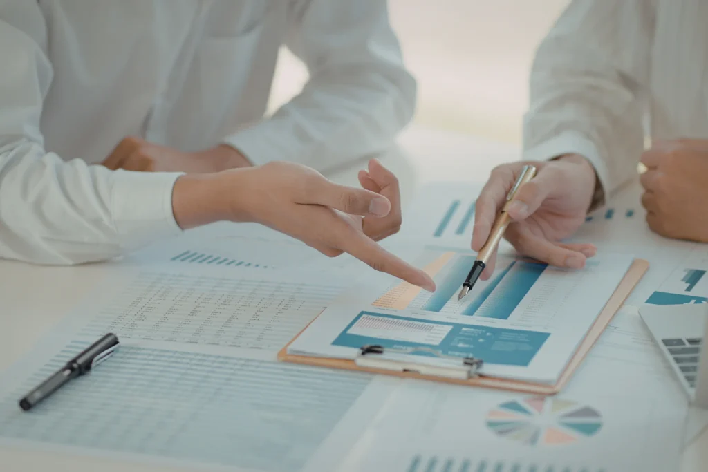 entrepreneurs reviewing tables and charts to create business' New Year's resolutions