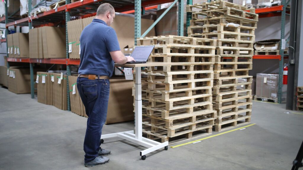 warehouse storage optimization: man checking inventory on laptop