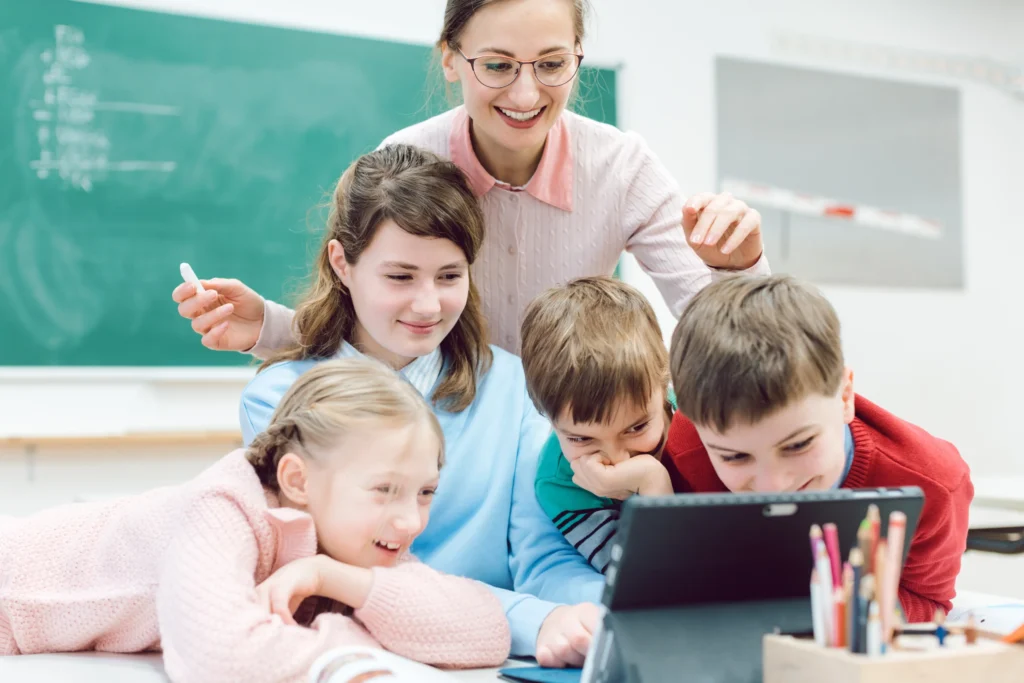 Special Education Service Providers: kids and teacher in classroom in front of tablet