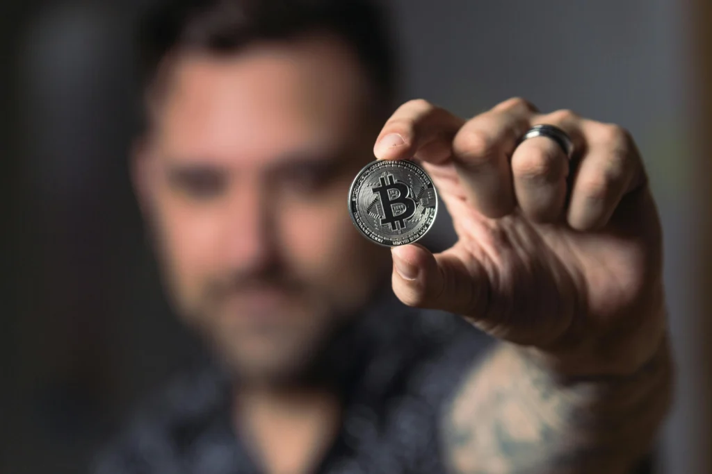 man holding a bitcoin: accept crypto payments