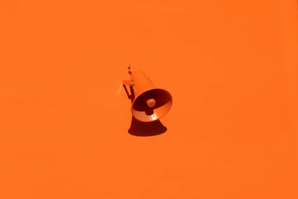 Orange megaphone on an orange wall