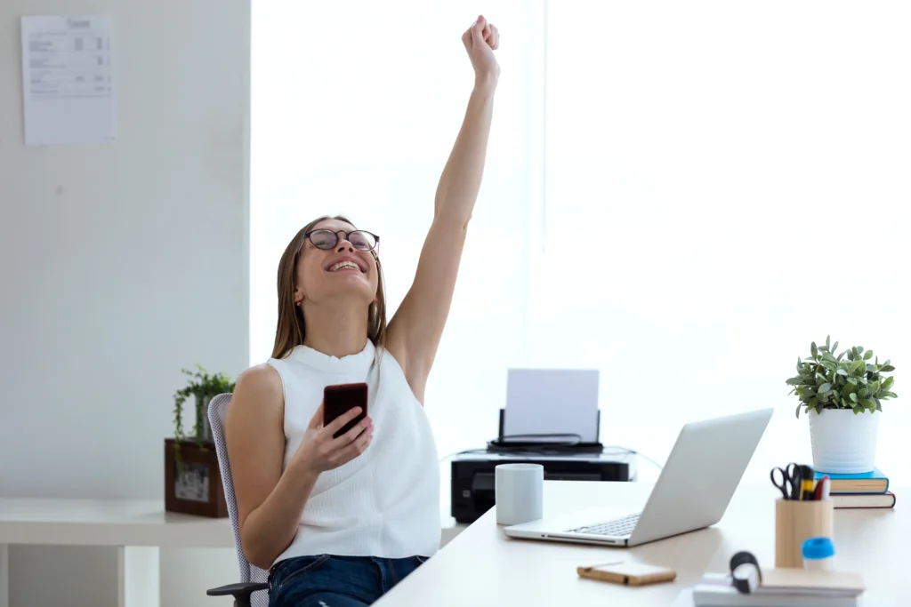 successful woman entrepreneur in first year of business raising hands