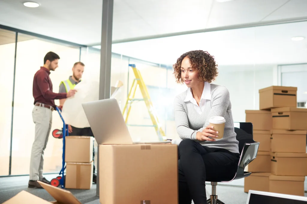 woman working on top of boxes as moving your business